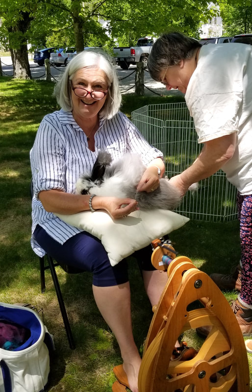 Demonstrating spinning at the Home Industries in 2019. Cathy is spinning right from one of Diane Johnson's bunnies…